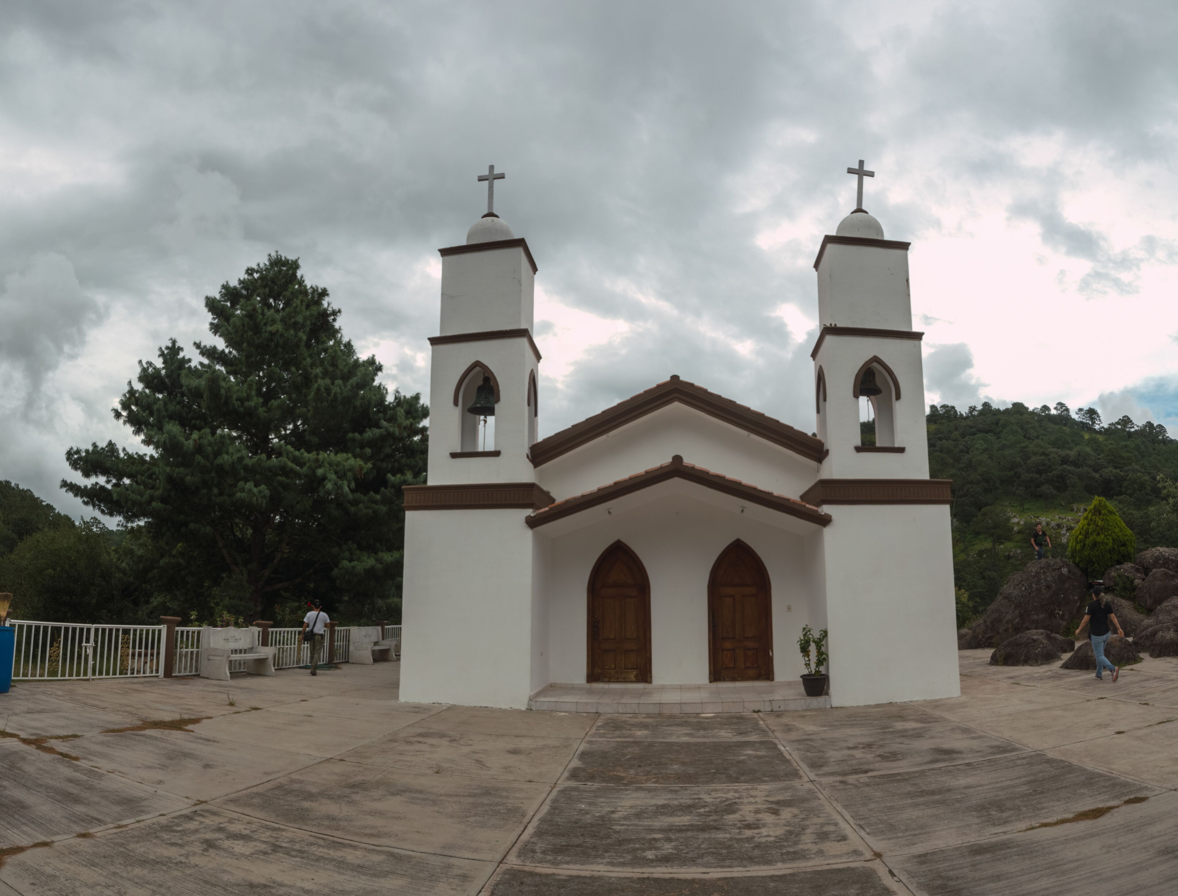 A small white church with two bell towers and a cross on top.