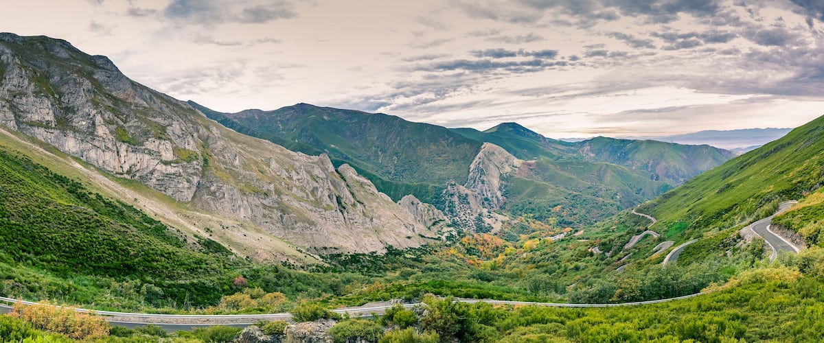 Een bergachtig landschap met een kronkelende weg.
