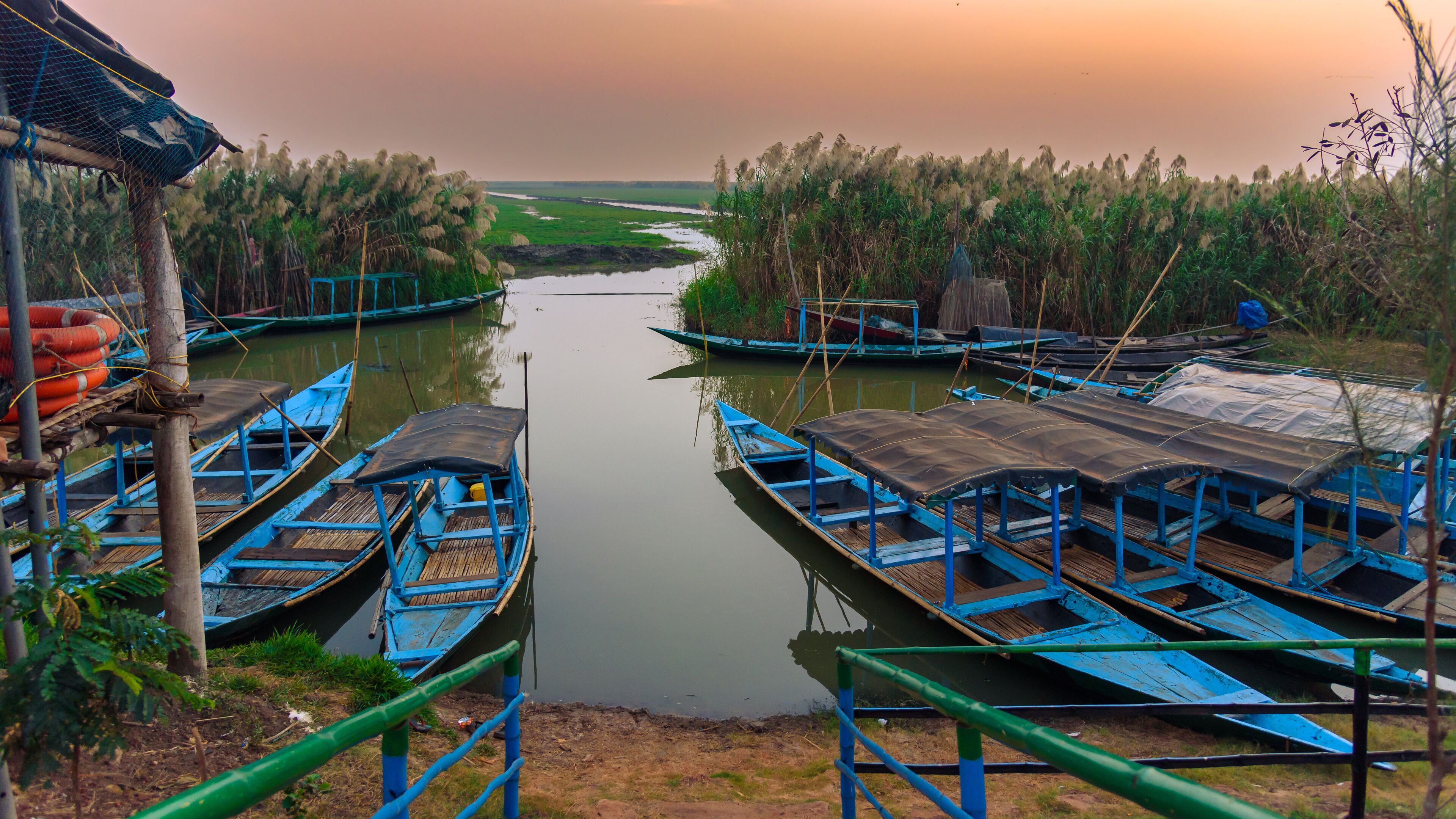 A calm river with boats docked on both sides.