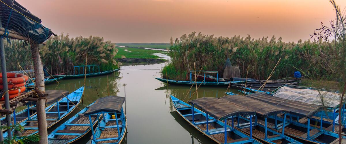 A calm river with boats docked on both sides.