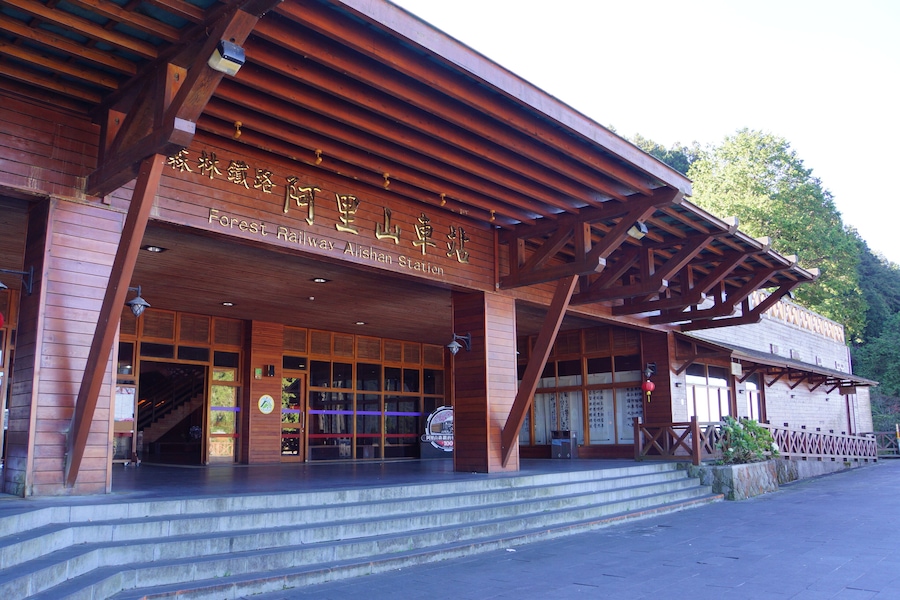 A wooden building with a sign that reads "Forest Railway Station".