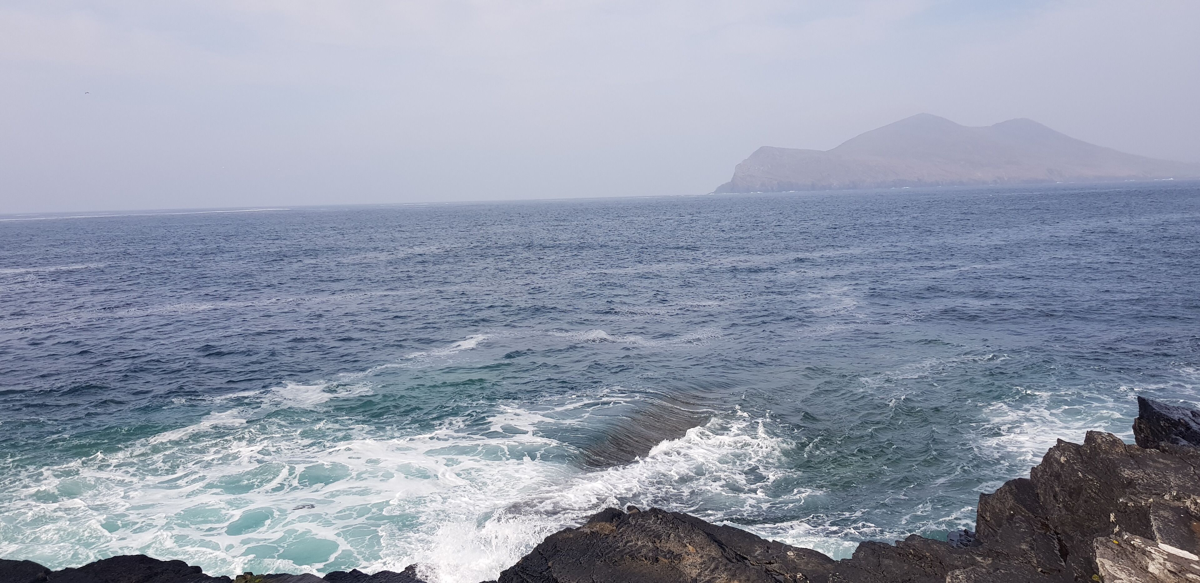 A rocky coastline with waves crashing against the rocks.