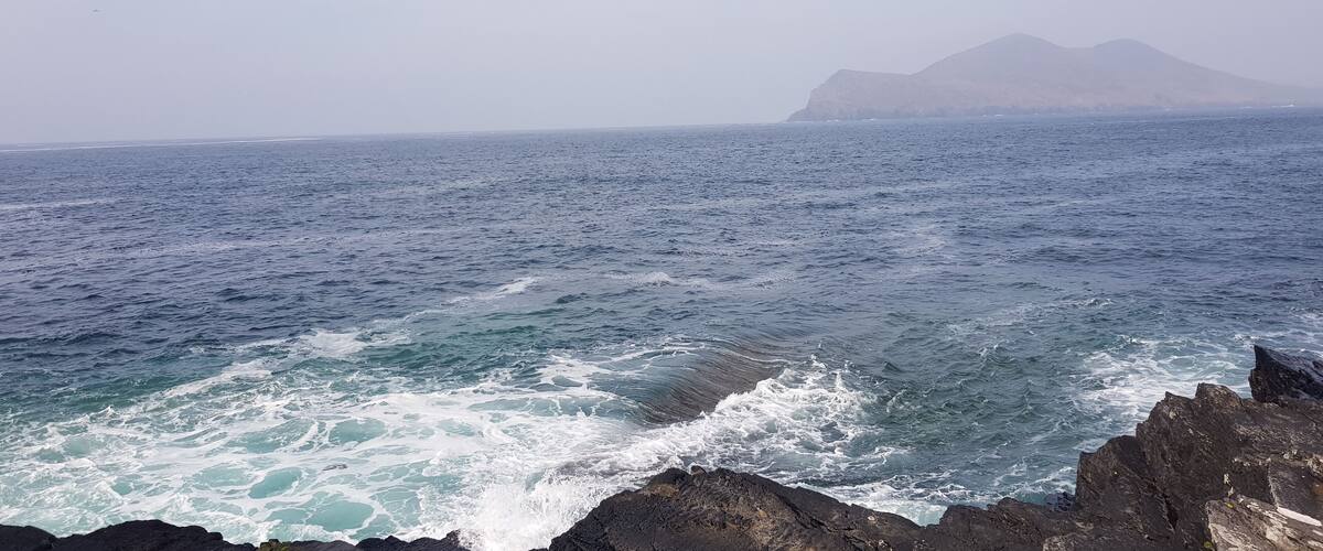 A rocky coastline with waves crashing against the rocks.