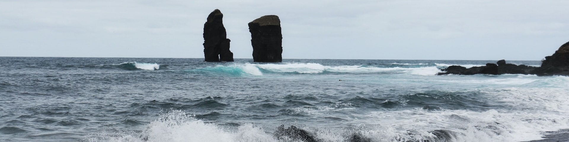 This little black sand beach was beautiful. Nice views, beginner surfers, and even a bit of sea glass.