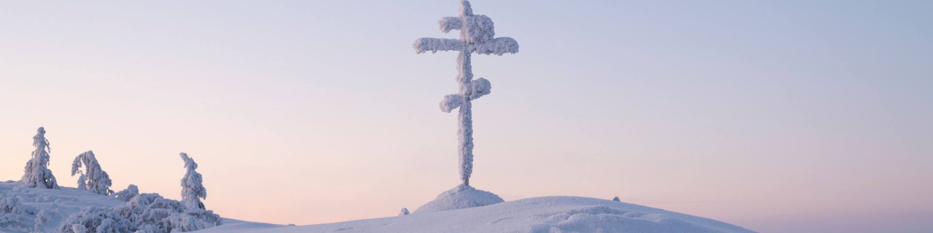 Snow-covered Cross on the Olchansky Pass near the village of Ust-Nera, Oymyakon District, Sakha Republic, Russia. The cross is installed near a dangerous Kolyma highway, called the road on bones