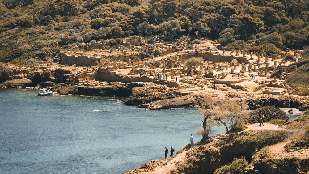 Wide angle panorama of the ruins of the Roman Archeological Park of Tipaza, Tipasa, Algeria. Tourists on the site.