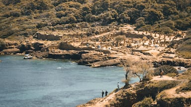 A coastal archaeological site with ruins and a clear blue sea.