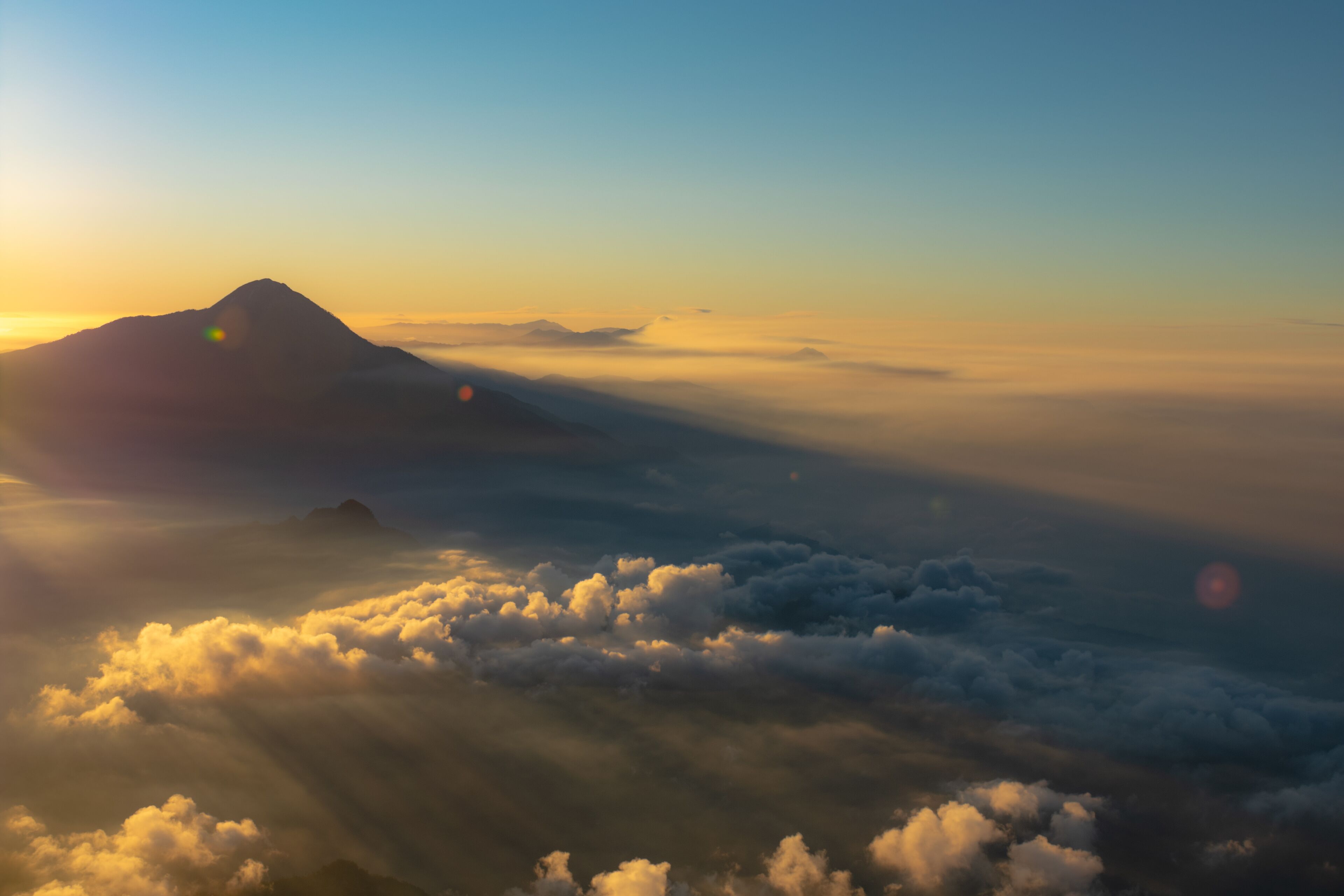 A mountain range with clouds below.