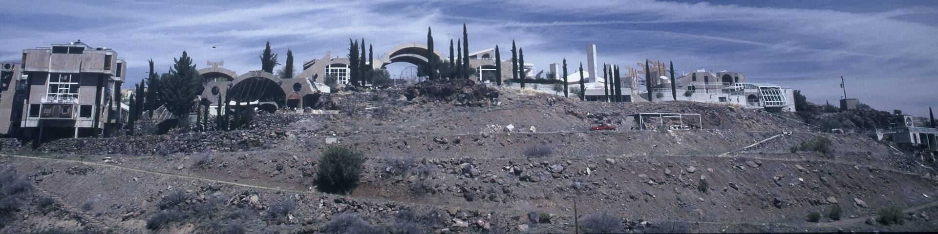 A ruined landscape with overcast skies and scattered buildings.