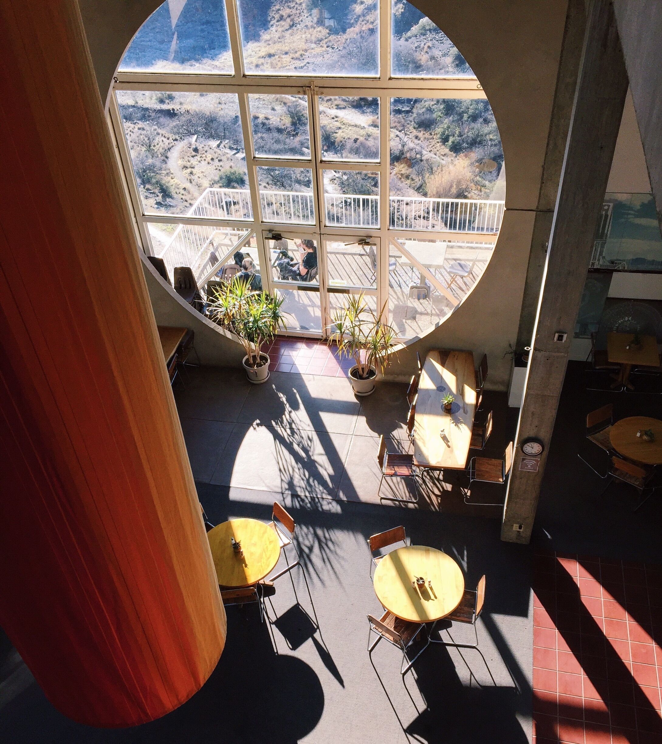 A café with large windows overlooking a mountainous landscape.