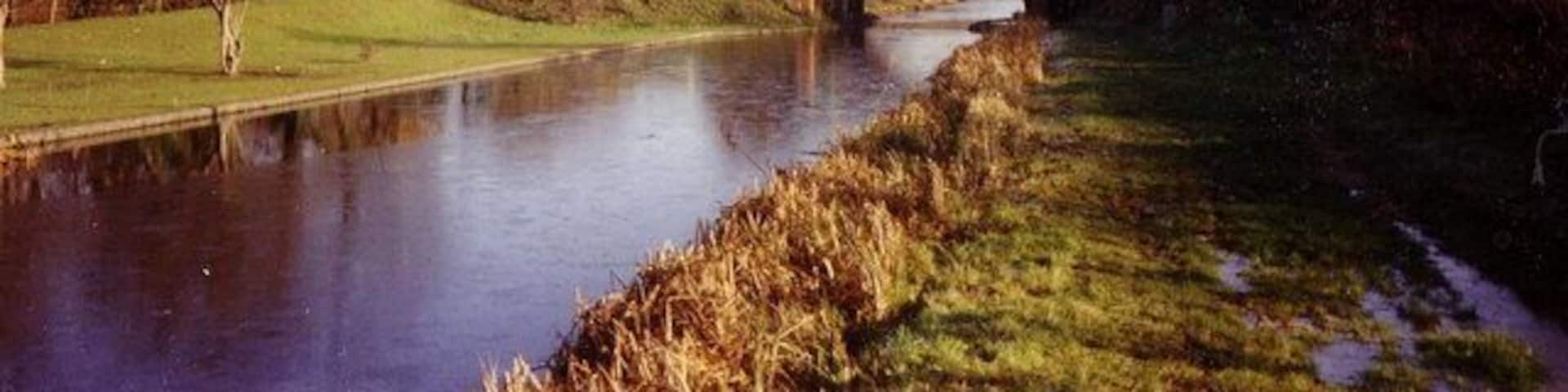 Grand Union Canal, Slough arm. A view eastwards along a boggy towpath towards the bridge carrying Middlegreen Road over the canal.