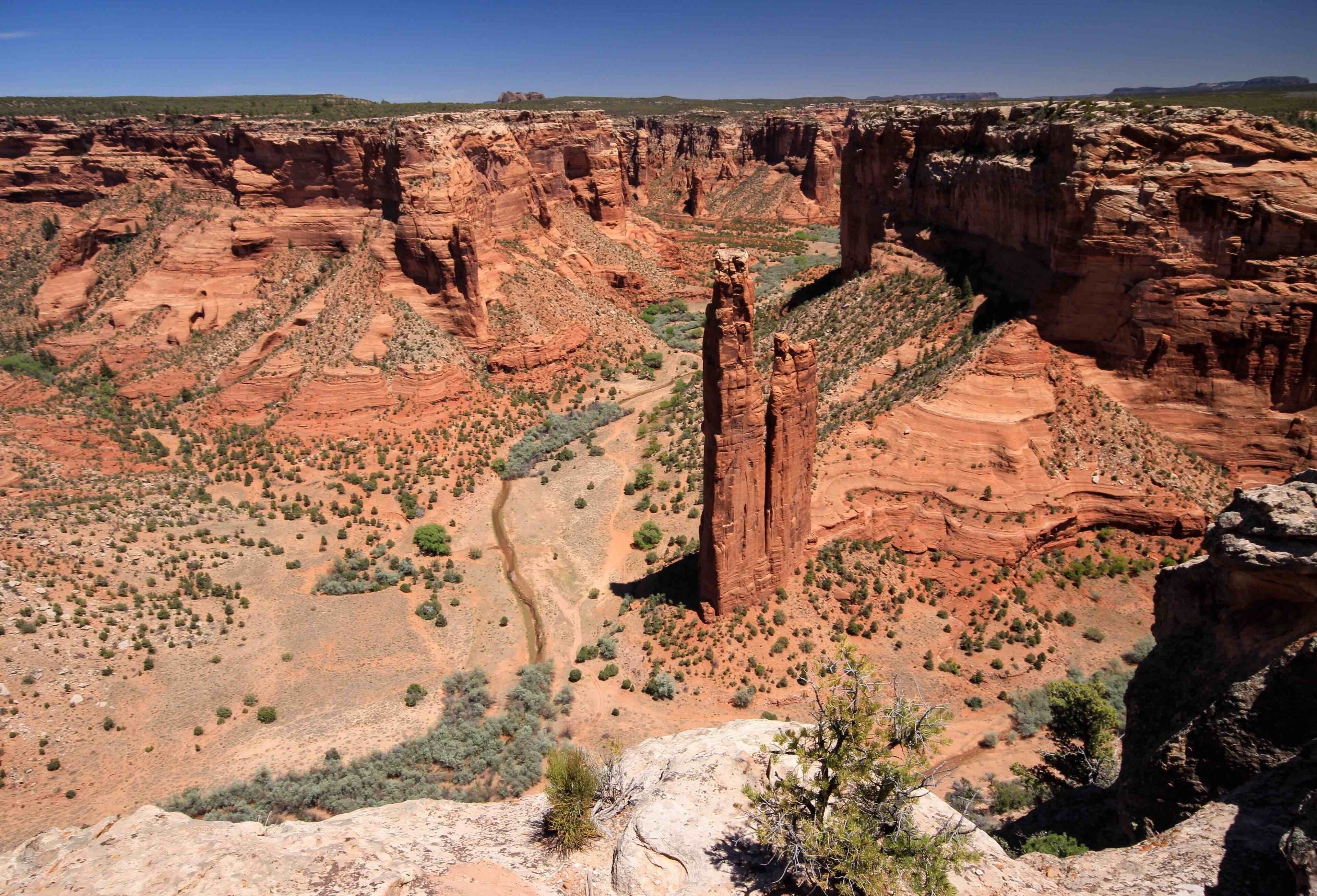 Spider Rock at Canyon De Chelly in Arizona. The tallest of the two sandstone spires is 750 feet (229 m) and located at the far end of the southern rim. The park is a great place for hiking and offers many opportunities to see ancient cave dwellings.