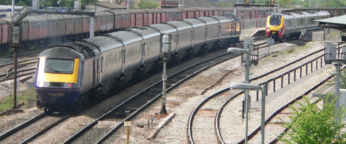 A westbound First Great Western HST enters Bristol Parkway railway station while a northbound Class 220 Virgin Voyager departs. This photograph was taken looking west from the bridge over the railway just off Hambrook Lane, Stoke Gifford about 1 third of a mile east of the station.