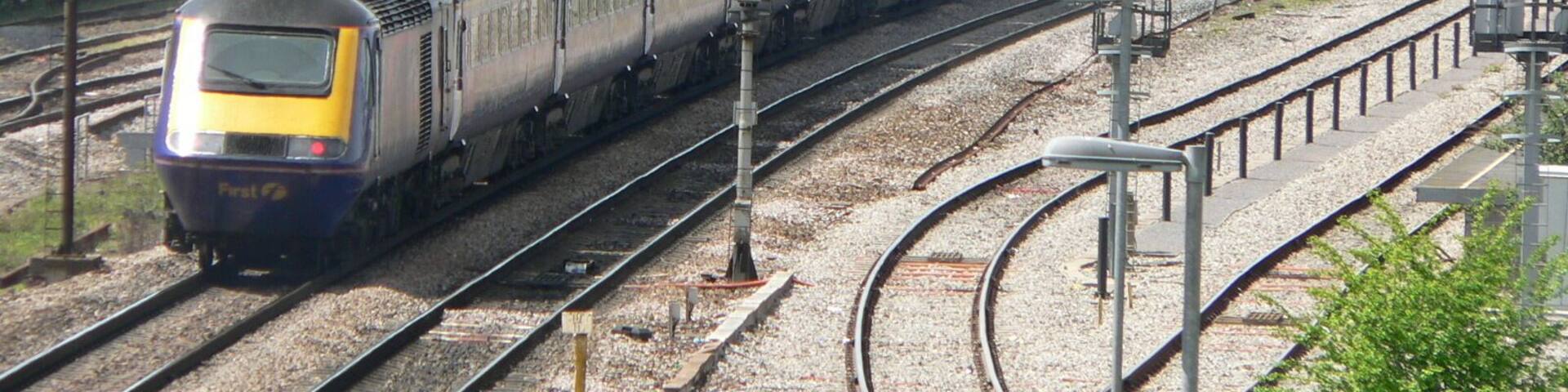 A westbound First Great Western HST enters Bristol Parkway railway station while a northbound Class 220 Virgin Voyager departs. This photograph was taken looking west from the bridge over the railway just off Hambrook Lane, Stoke Gifford about 1 third of a mile east of the station.