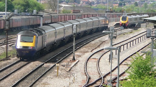 A westbound First Great Western HST enters Bristol Parkway railway station while a northbound Class 220 Virgin Voyager departs. This photograph was taken looking west from the bridge over the railway just off Hambrook Lane, Stoke Gifford about 1 third of a mile east of the station.