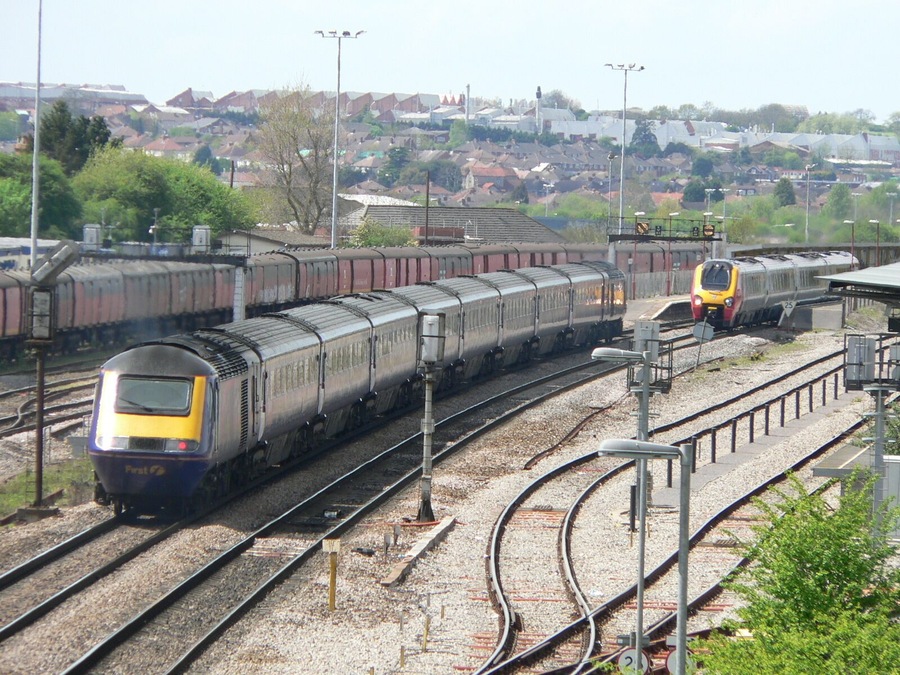 A westbound First Great Western HST enters Bristol Parkway railway station while a northbound Class 220 Virgin Voyager departs. This photograph was taken looking west from the bridge over the railway just off Hambrook Lane, Stoke Gifford about 1 third of a mile east of the station.