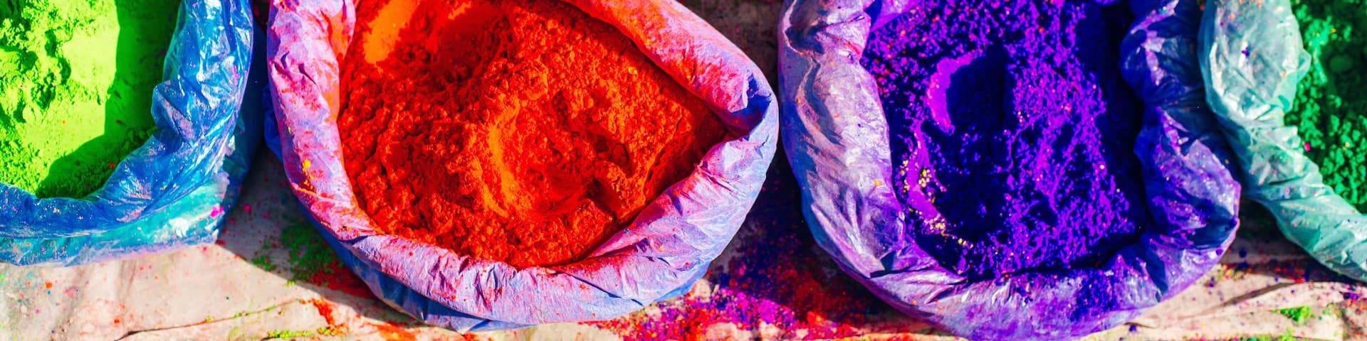 very bright multicolored paint powders in bags and a small spoon. paints for the holiday of Holi