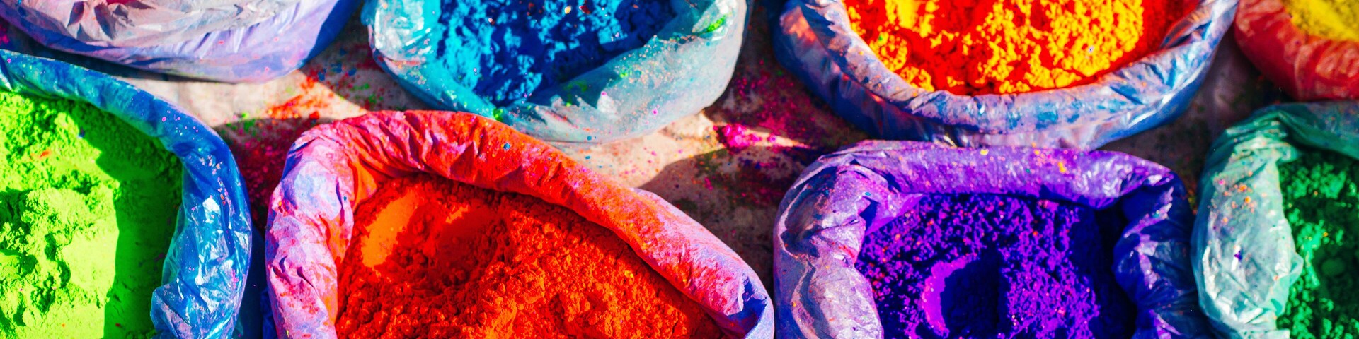 very bright multicolored paint powders in bags and a small spoon. paints for the holiday of Holi