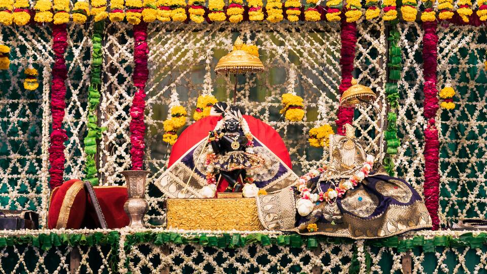 A decorated shrine with intricate floral arrangements and a central deity figure.