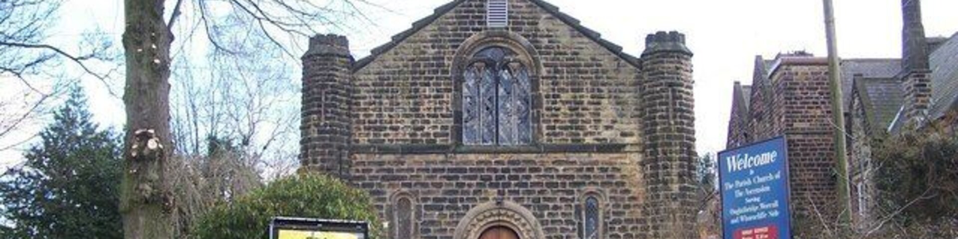 Una iglesia de piedra histórica con un letrero acogedor.
