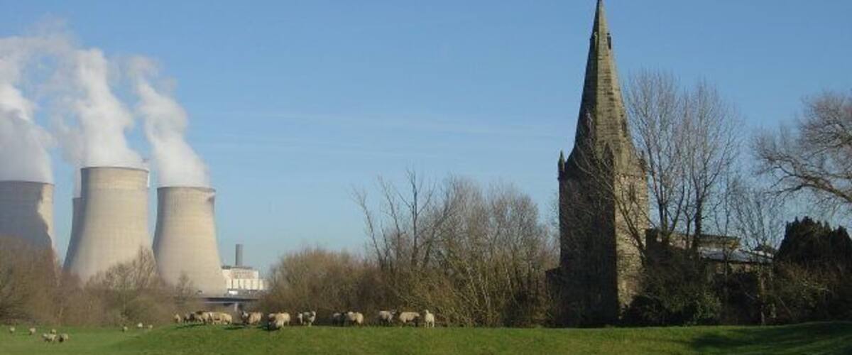 Sheep on the bank The bank provides flood defence for the village of Ratcliffe on Soar. The tower (13C) and broach spire (14C) of the church contrast with the modern power station.