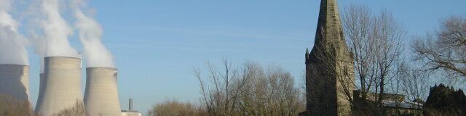 Sheep on the bank The bank provides flood defence for the village of Ratcliffe on Soar. The tower (13C) and broach spire (14C) of the church contrast with the modern power station.