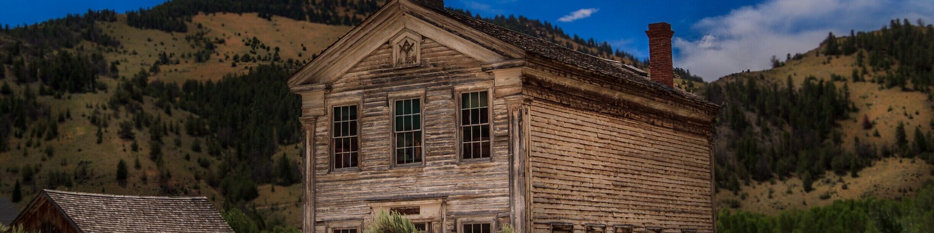 Founded in 1862 and named after the local Bannock Indians, it was the site of a major gold discovery in 1862, and served as the capital of Montana Territory briefly in 1864, until the capital was moved to Virginia City. Bannack continued as a mining town, though with a dwindling population. The last residents left in the 1970s.
At its peak, Bannack had a population of about ten thousand. Extremely remote, it was connected to the rest of the world only by the Montana Trail. There were three hotels, three bakeries, three blacksmith shops, two stables, two meat markets, a grocery store, a restaurant, a brewery, a billiard hall, and four saloons. Though all of the businesses were built of logs, some had decorative false fronts.