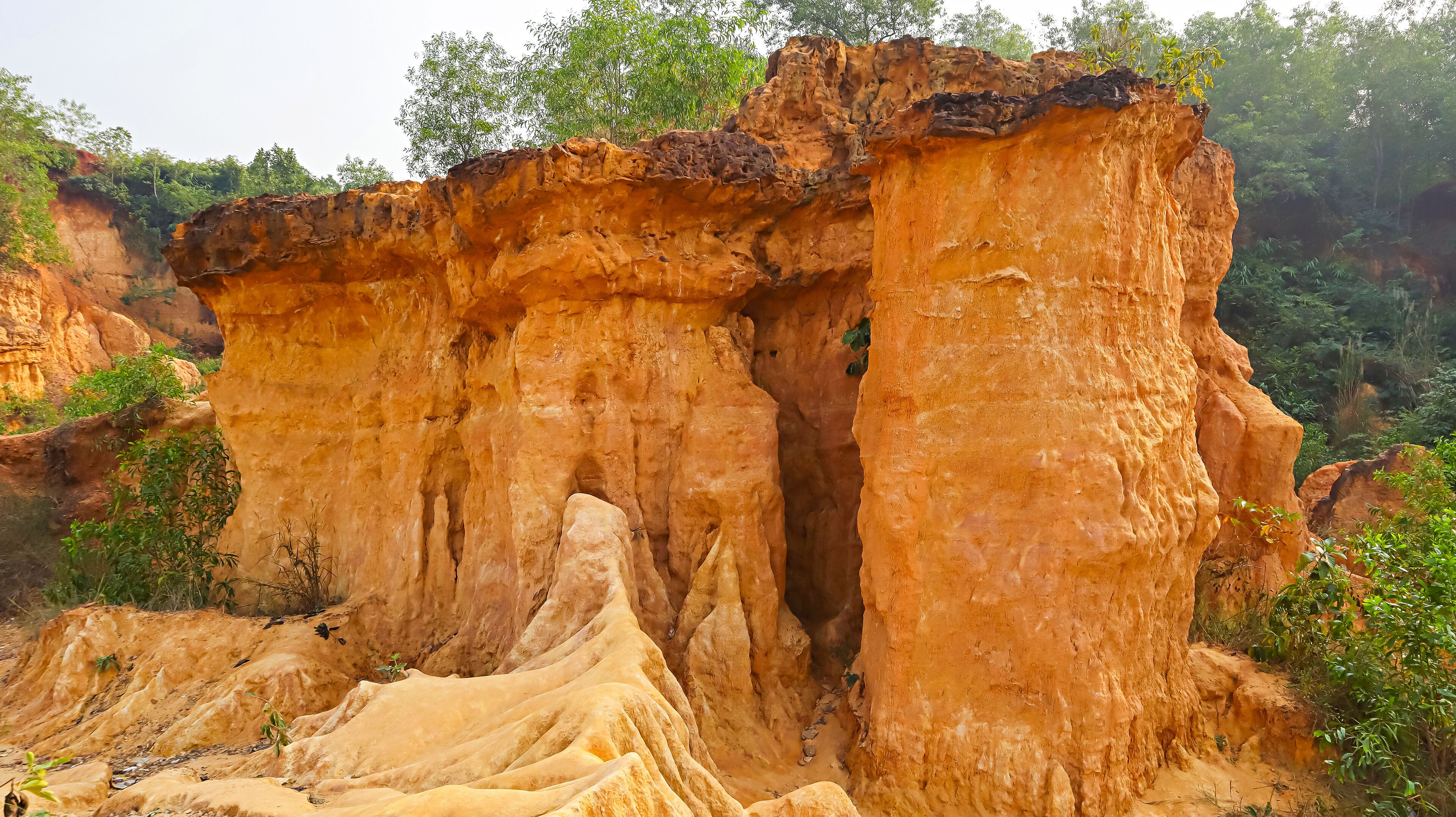 A large, rugged rock formation with a narrow passageway.
