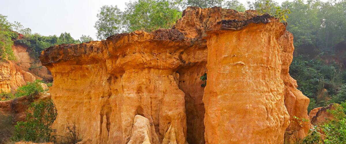 A large, rugged rock formation with a narrow passageway.
