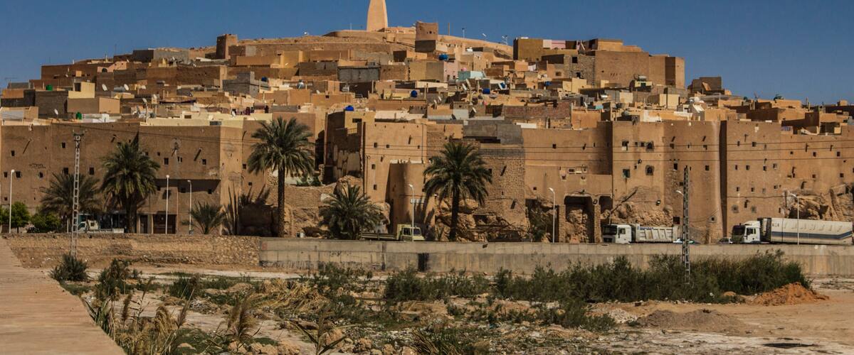 A desert cityscape with a prominent minaret and dense, low-rise buildings.