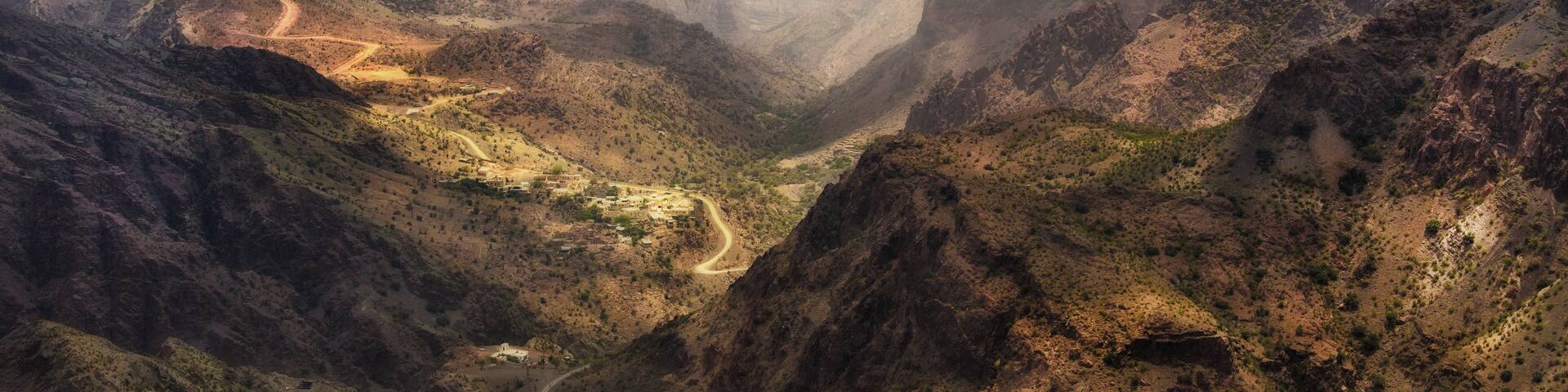 A canyon with a winding road and a small settlement.