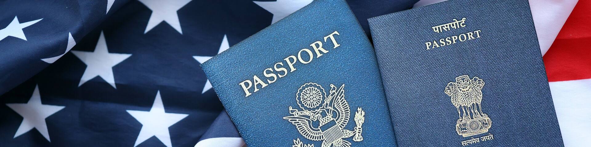 Passport of India with US Passport on United States of America folded flag close up