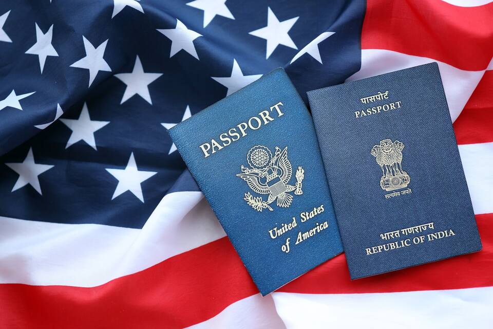 Two passports, one from the United States and one from India, placed on an American flag.