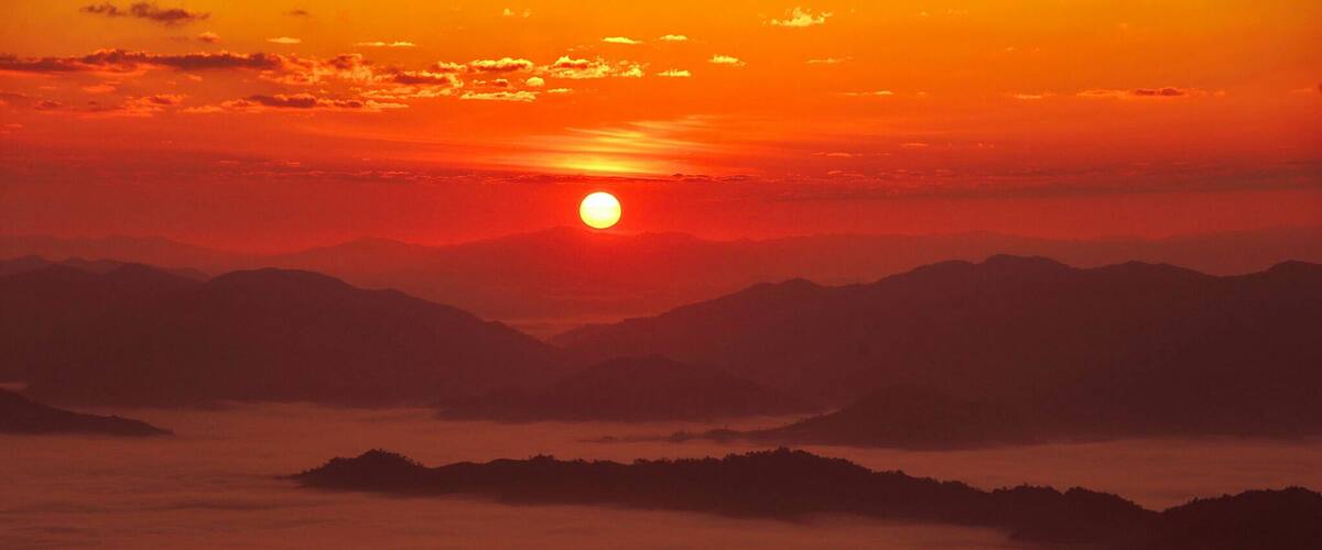 Sunrise over Laos. Phu Chi Fa is well known by the local Thai people but very few foreign travelers heard of the place. The view is worth the 30 minute hike!!