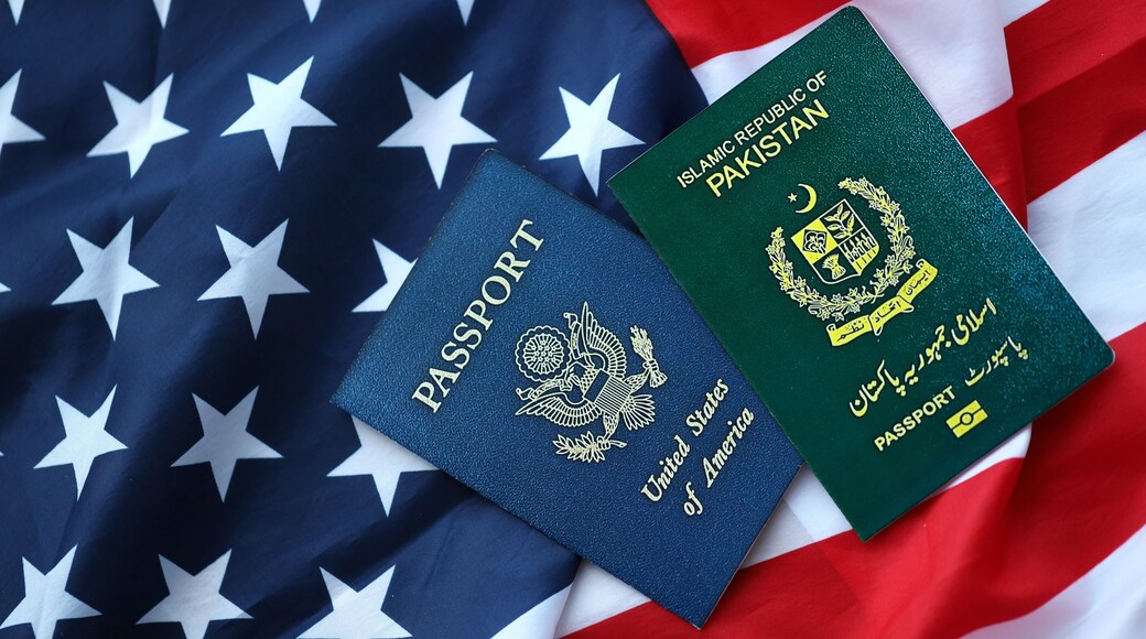 Passport of Pakistan with US Passport on United States of America folded flag close up