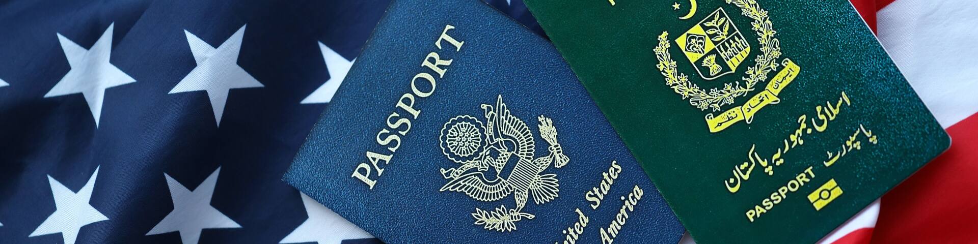 Passport of Pakistan with US Passport on United States of America folded flag close up
