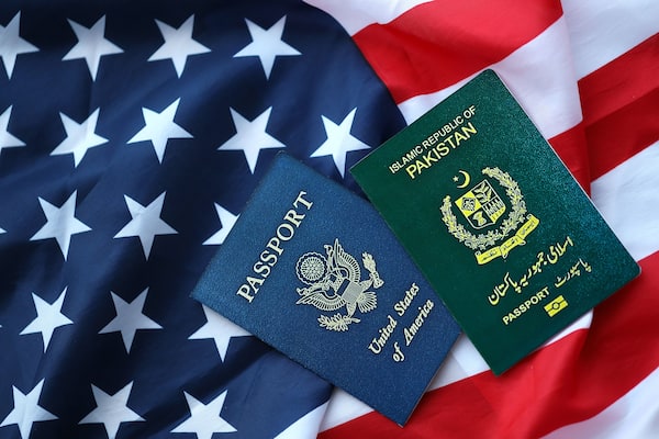 Passport of Pakistan with US Passport on United States of America folded flag close up