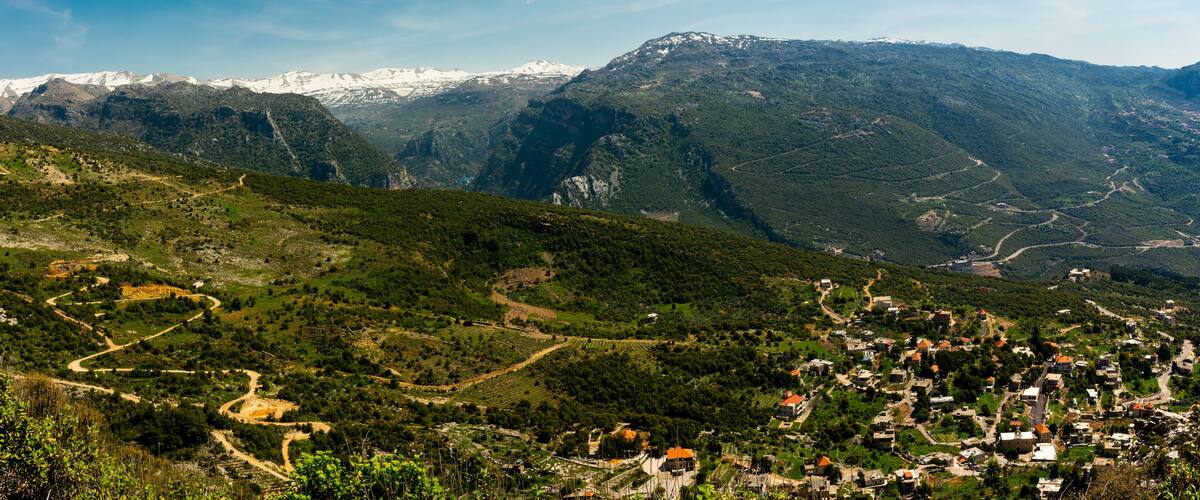 A mountainous landscape with a village nestled in the valley.