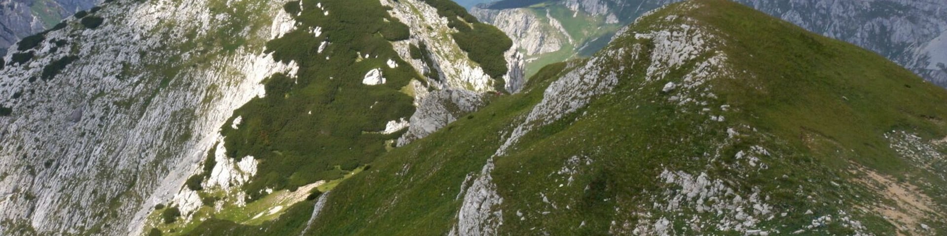 Panorama from the summit of Prutas is amazing! From here it is most beautiful view of Skrka Valley and highest peak of Durmitor, Bobotov Kuk, which rules on the other side of the valley, on the NE. Also very close is colorful Stit with its amazing twisted layers of limestone cliffs, on the E. On the N is Susica canyon and Ljubisnja mountain farther away. On the S are vast grassy plateaus and basins of Durmitor closed by elegant Sedlena Greda and picturesque ridges of Boljska Greda and Lojanik. Further away is Vojnik mountain and on clear days views spreads far south, ell the way to Orjen massif and the Adriatic coast. On the W are even larges grassy plateaus of Pivska Planina. Behind it is beautiful group of mountains led by Bioc and Maglic, highest peak of Bosnia & Herzegovina.