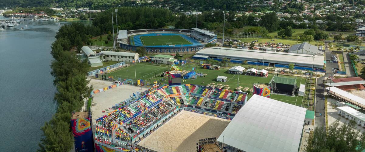 Mahé, Seychelles - 04 May 2025: Aerial view of vibrant stadium near the beach with lush mountains and tropical greenery, Roche Caiman, Mahe, Seychelles.