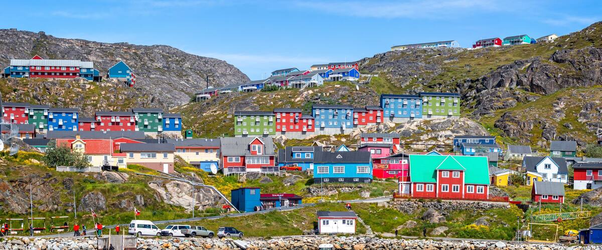 A colorful coastal village with houses on a hillside.
