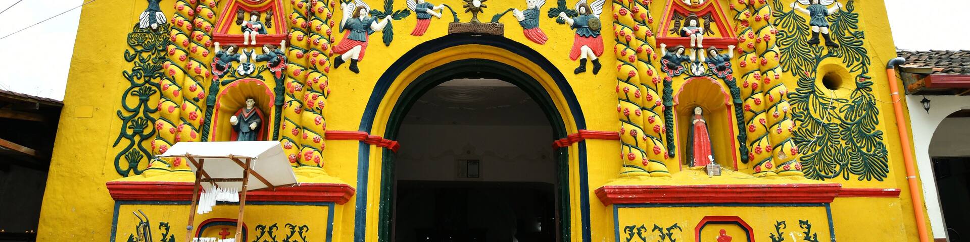 A brightly colored church with intricate murals and statues.