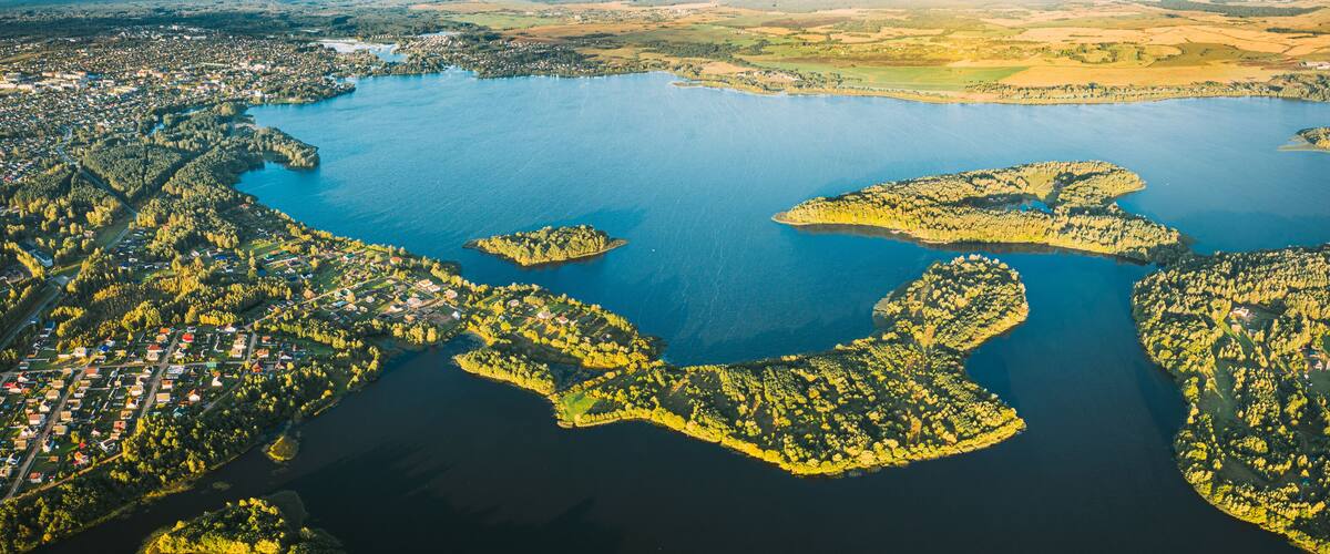 Lyepyel, Lepel Lake, Beloozerny District, Vitebsk Region. Aerial View Of Lyepyel Cityscape Skyline In Autumn Morning. Morning Fog Above Lepel Lake. Top View Of European Nature From High Attitude In