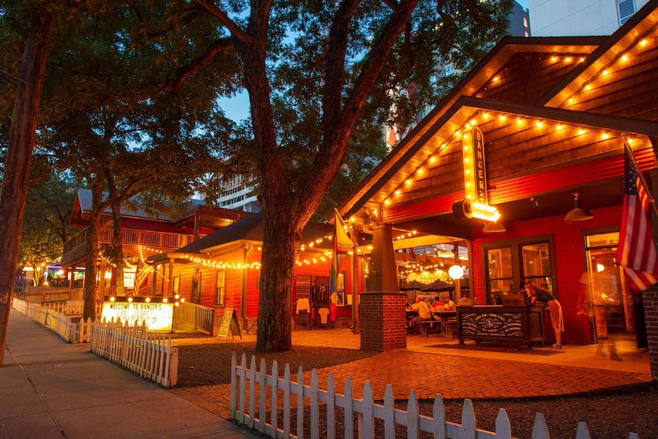 A wooden building with a red facade and a white picket fence.