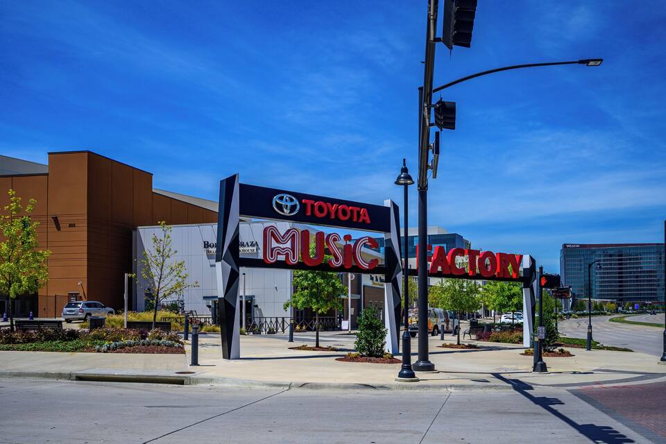 A Toyota Music Factory sign with a modern building in the background.