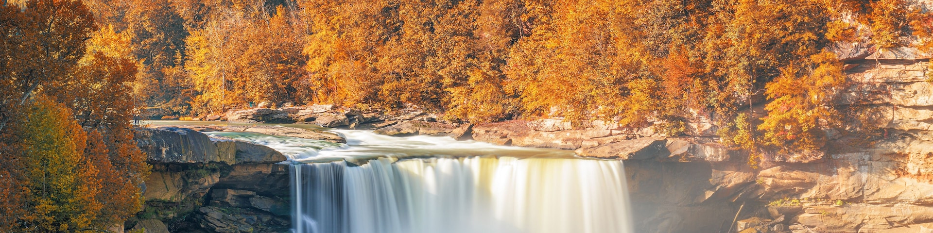 Une cascade entourée d’un feuillage automnal.