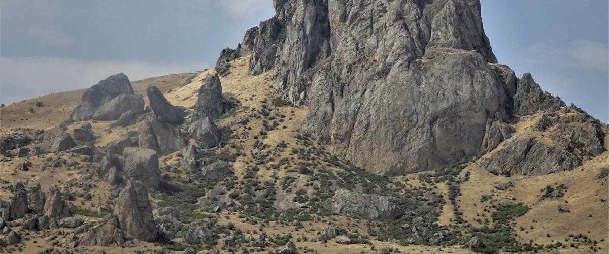 A rugged mountain peak with sparse vegetation.