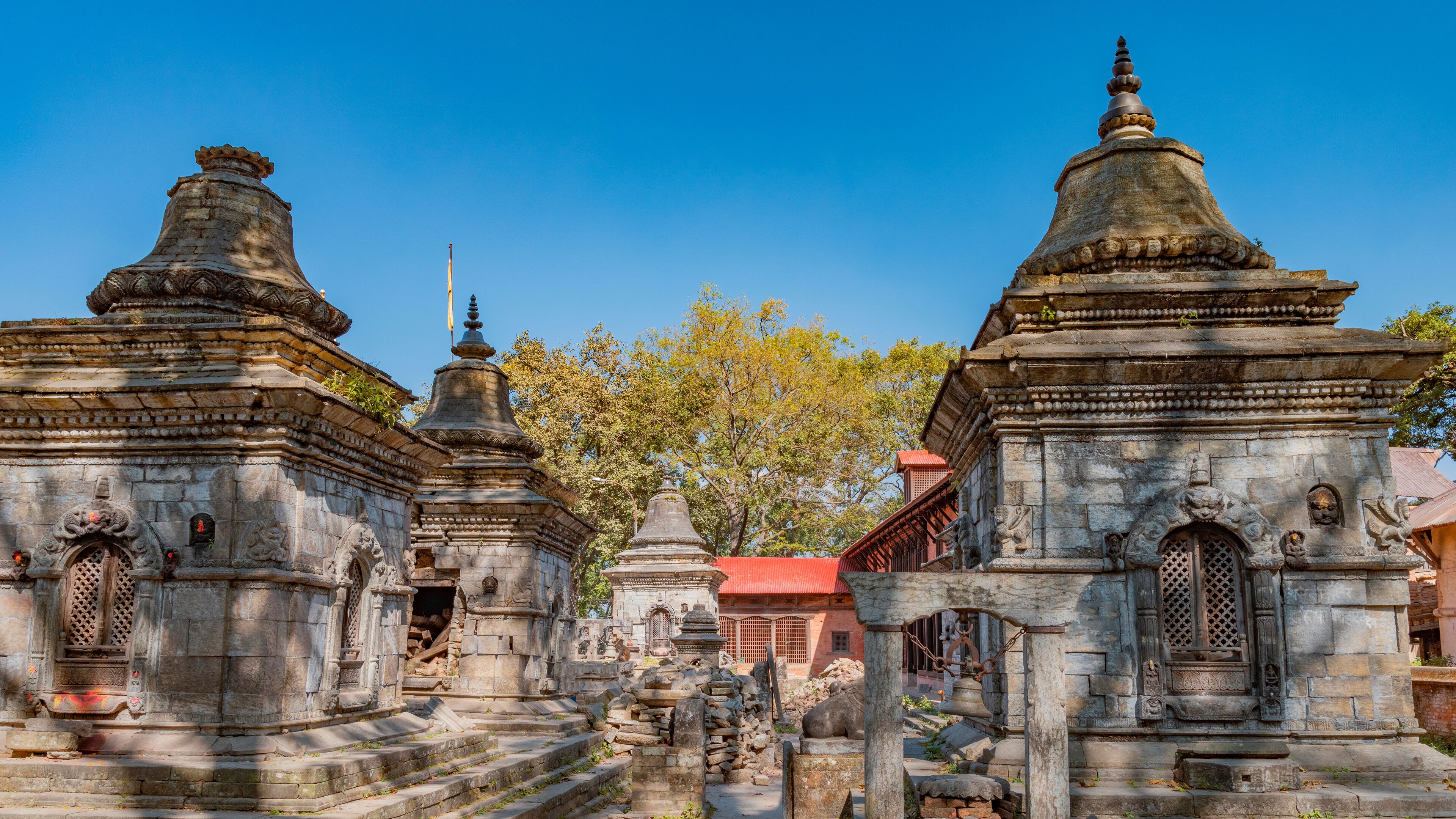 A temple complex with stone structures and a clear blue sky.