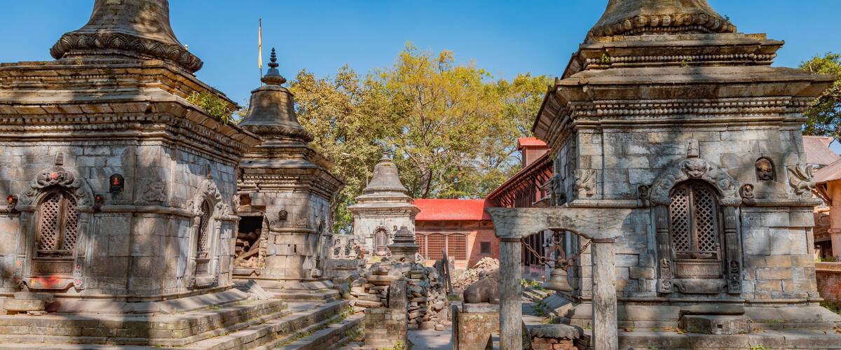 A temple complex with stone structures and a clear blue sky.