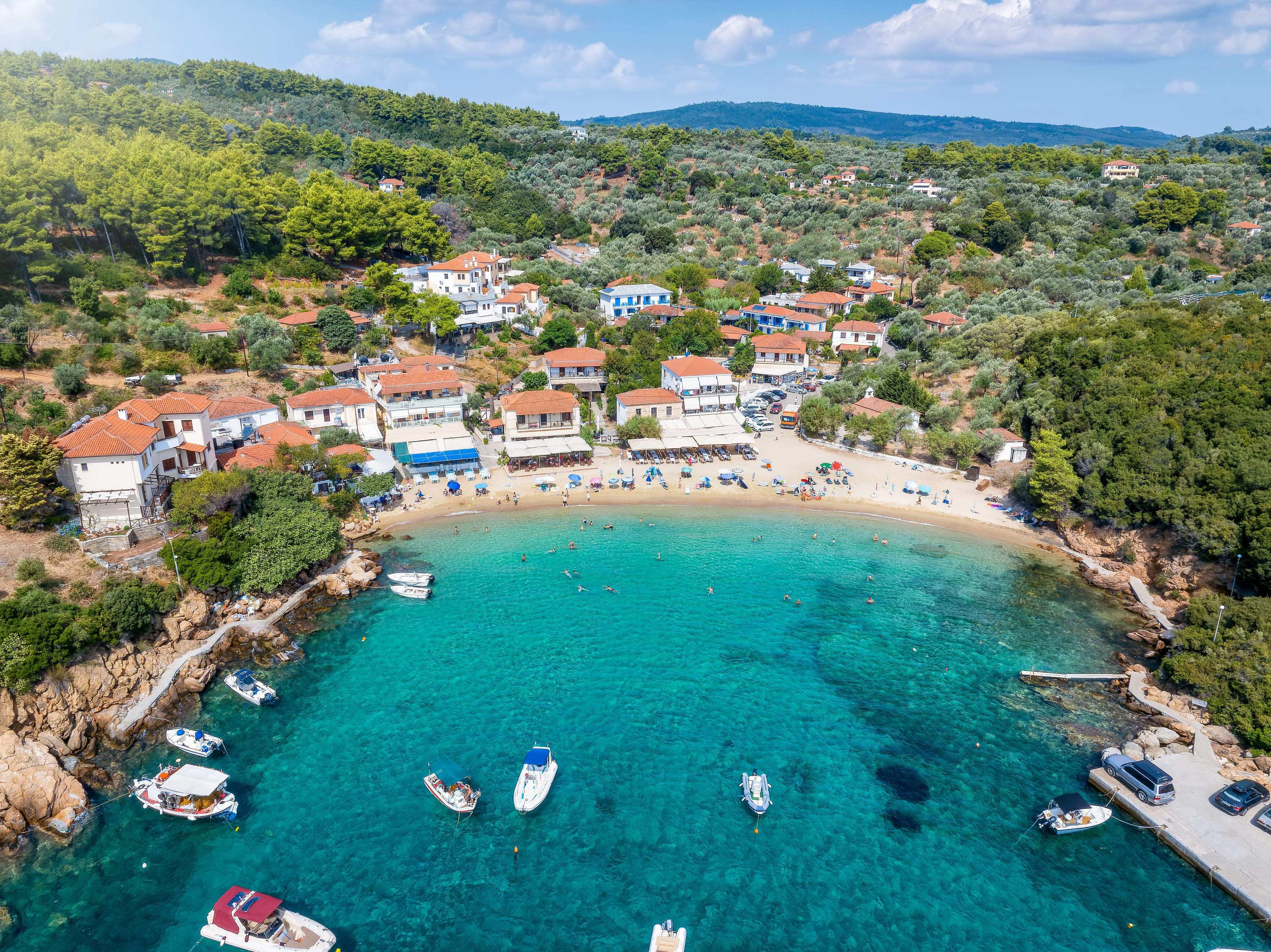 Aerial view of the idyllic fishing village of Katigiorgis, South Pelion, Greece, with turquoise, clear sea  during summer time